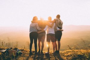 men and women hiking at sunset
