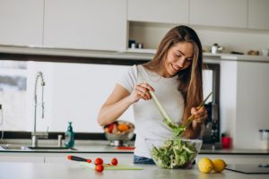 woman happily making a salad as she reconnects with food and hunger