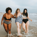 Three happy, curvy women at the beach.