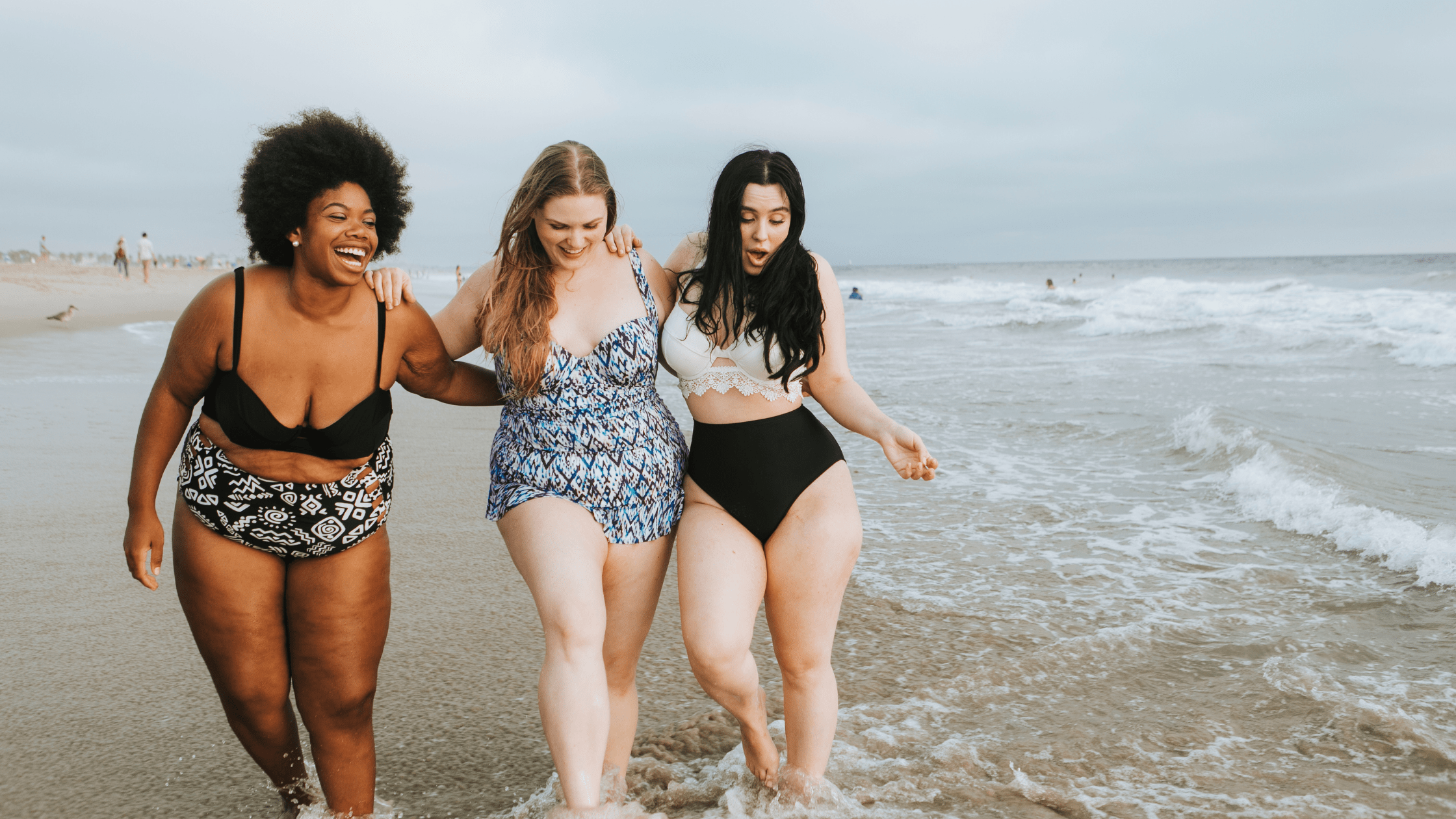 Three happy, curvy women at the beach.