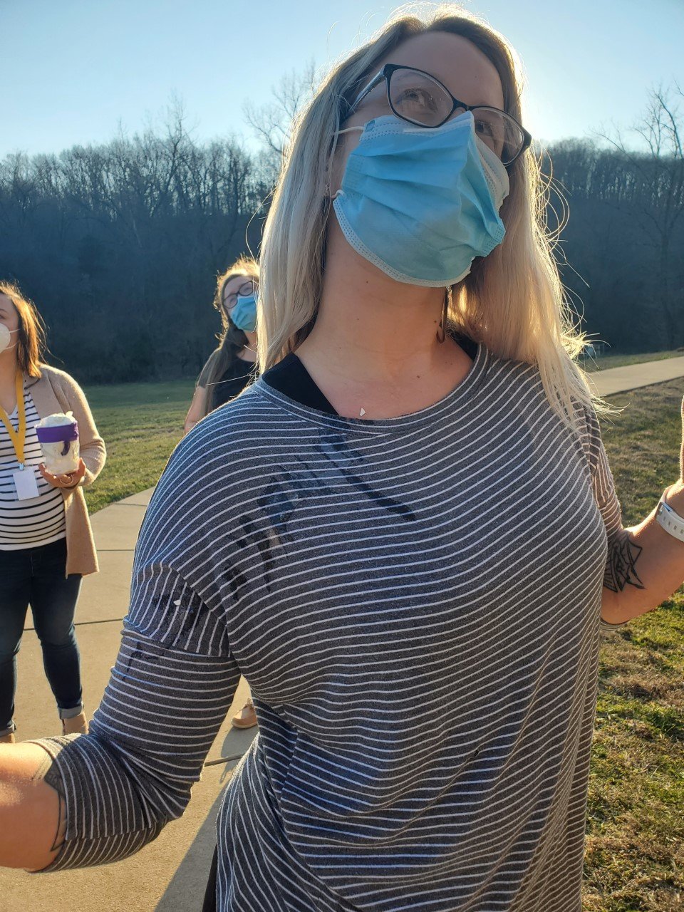 Woman outside in a striped shirt and mask
