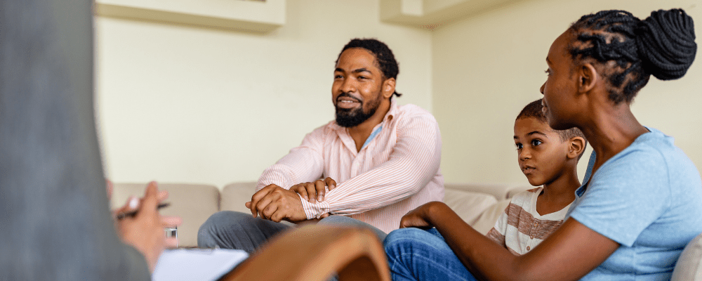 a family is engaging in a group therapy session; father is smiling, full of hope. Men and depression are commonly misunderstood.