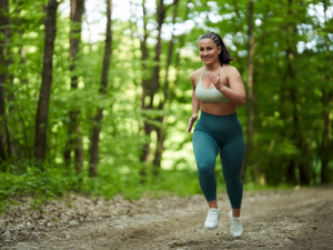 Focusing on health instead of weight can contribute to Positive body image; woman smiling and trail running