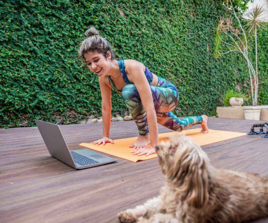 Woman doing yoga on a back porch while taking part in Virtual IOP for eating disorders at Alsana.