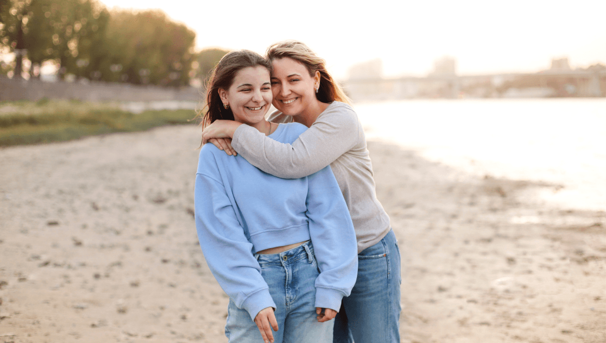 family hugging on beach